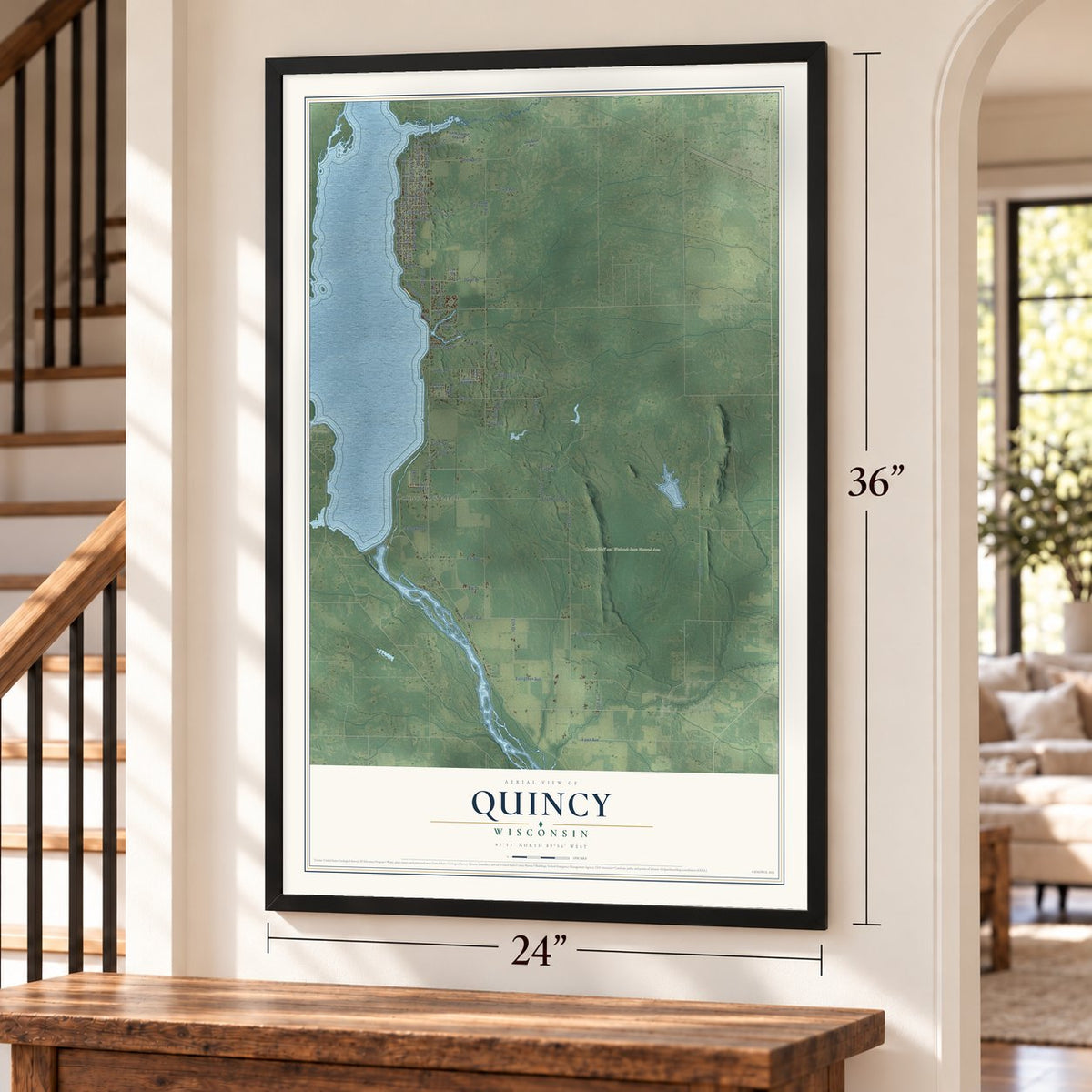 Quincy, Wisconsin map, 24 x 36 inch print in a black frame by a staircase