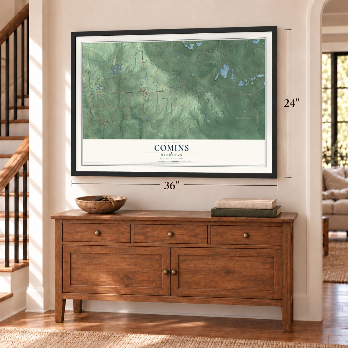 Comins, Michigan map, 24 x 36 inch print in a black frame above a dresser by a staircase