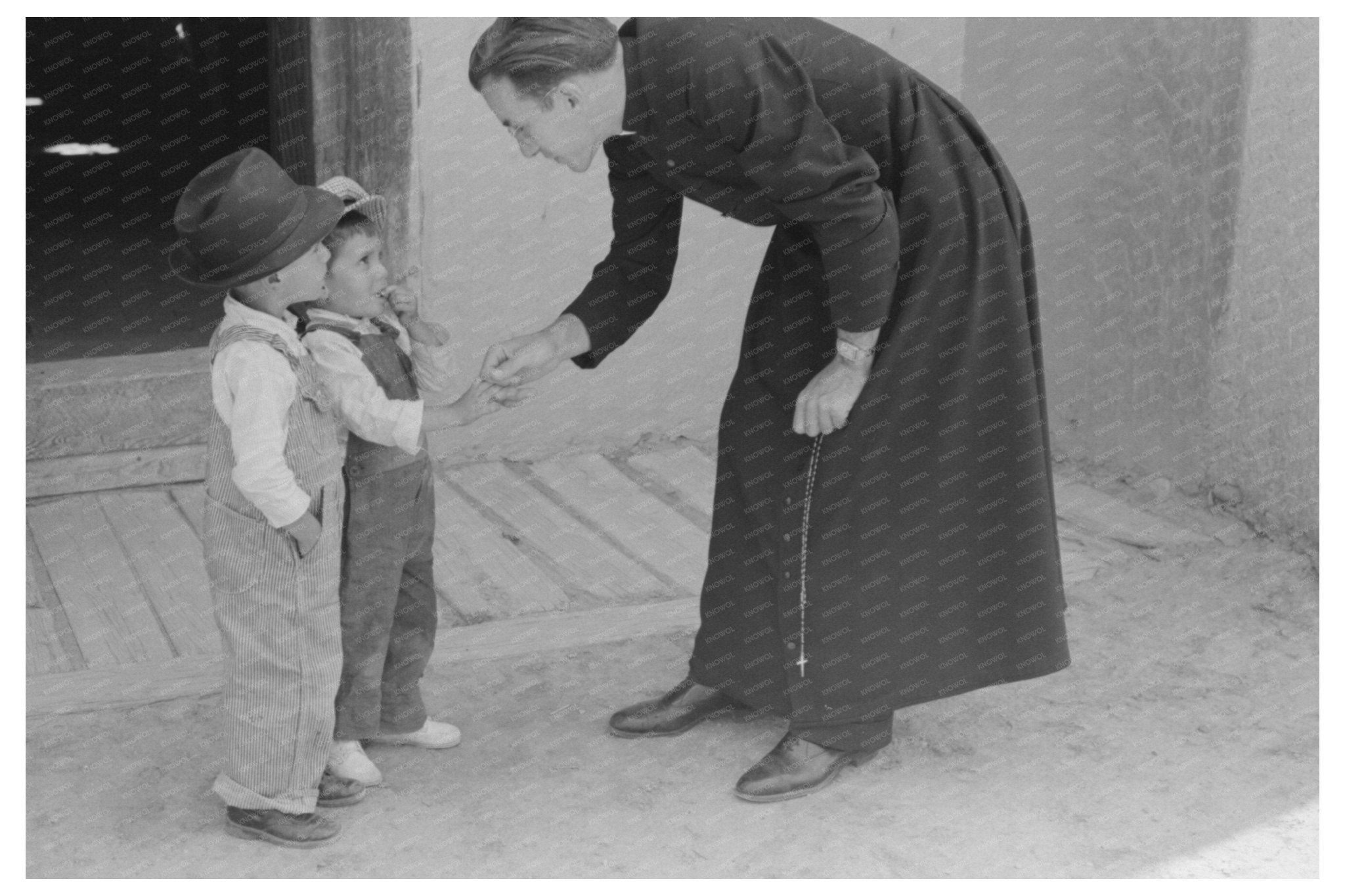 Catholic Priest Greets Boy After Mass Trampas New Mexico 1940 - Available at KNOWOL
