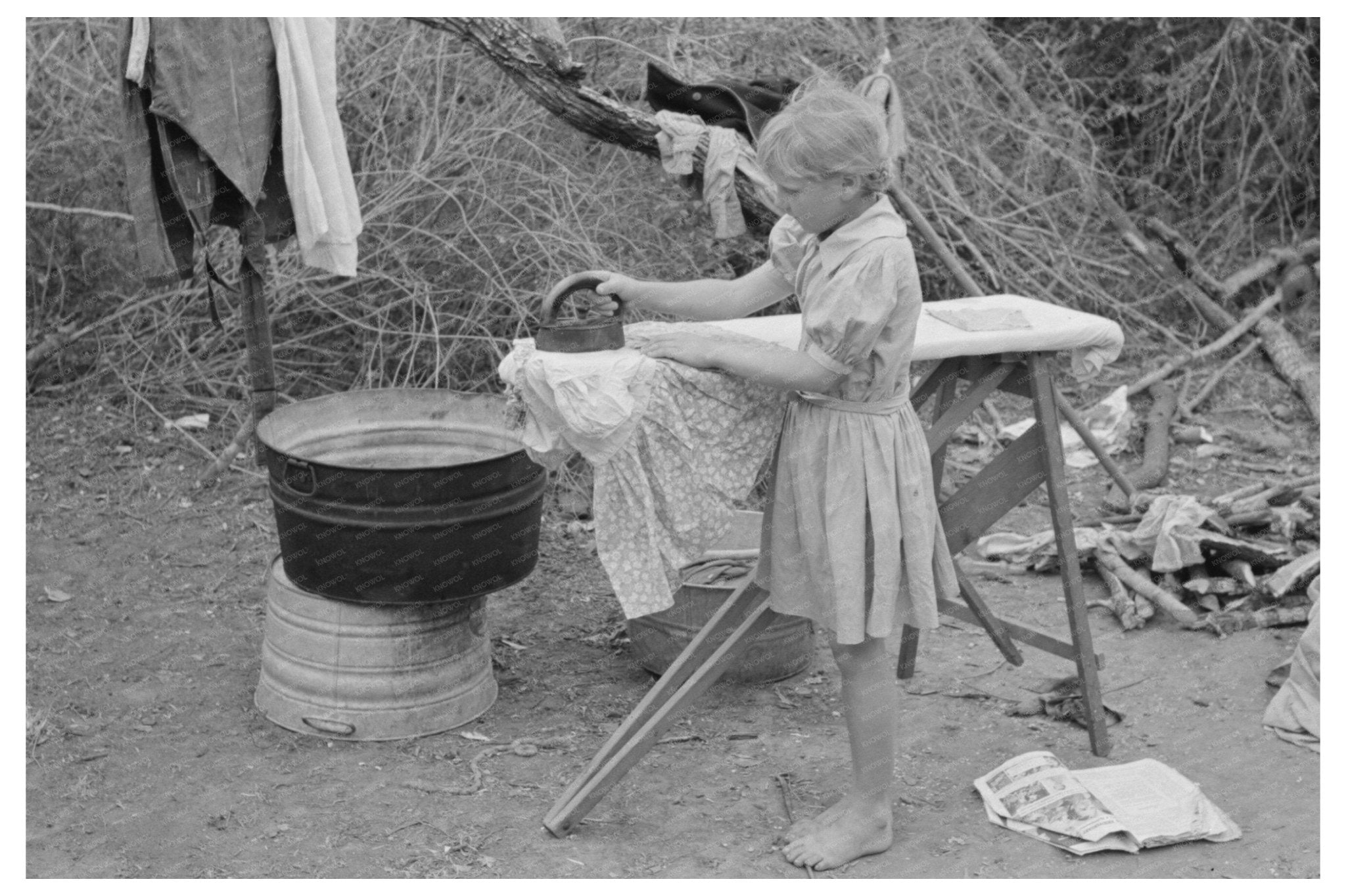 Child Ironing in Migrant Camp Harlingen Texas 1939 - Available at KNOWOL