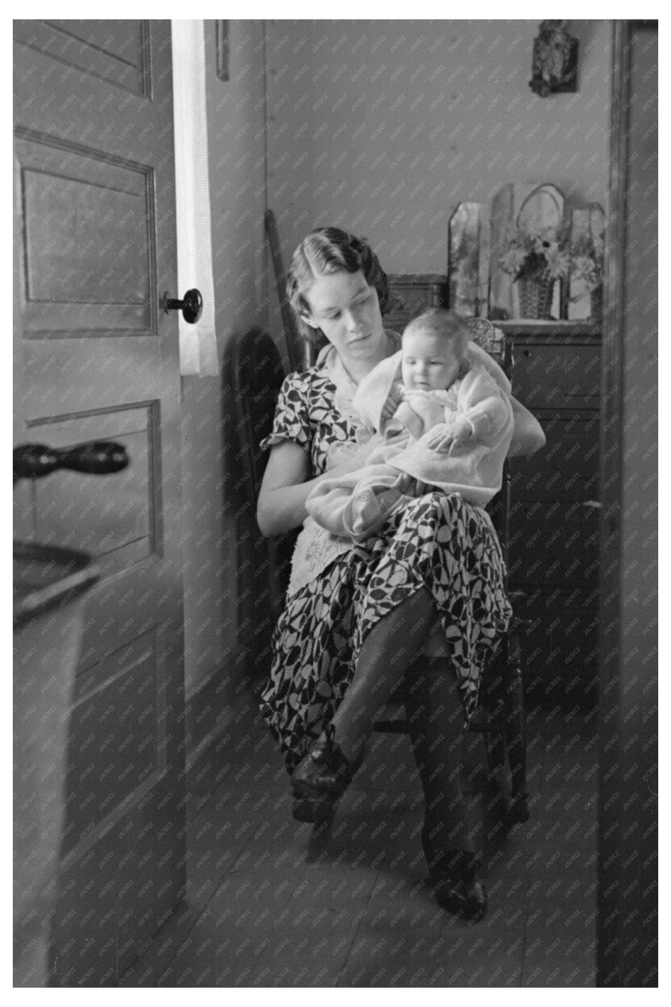 Child with Mother Reading Newspaper in Nissen Shack 1936 - Available at KNOWOL