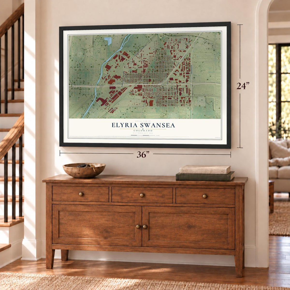 Elyria Swansea, Colorado map, 24 x 36 inch print in a black frame above a dresser by a staircase