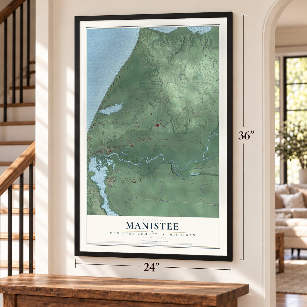 Manistee, Manistee County, Michigan map, 24 x 36 inch print in a black frame by a staircase
