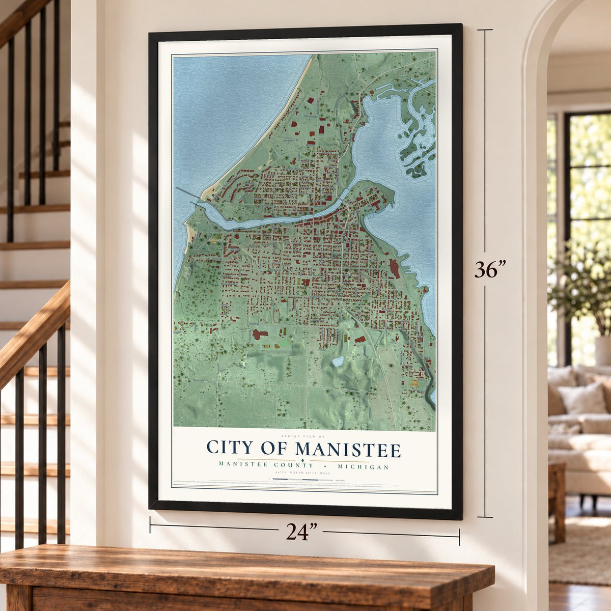 Manistee, Michigan map, 24 x 36 inch print in a black frame by a staircase
