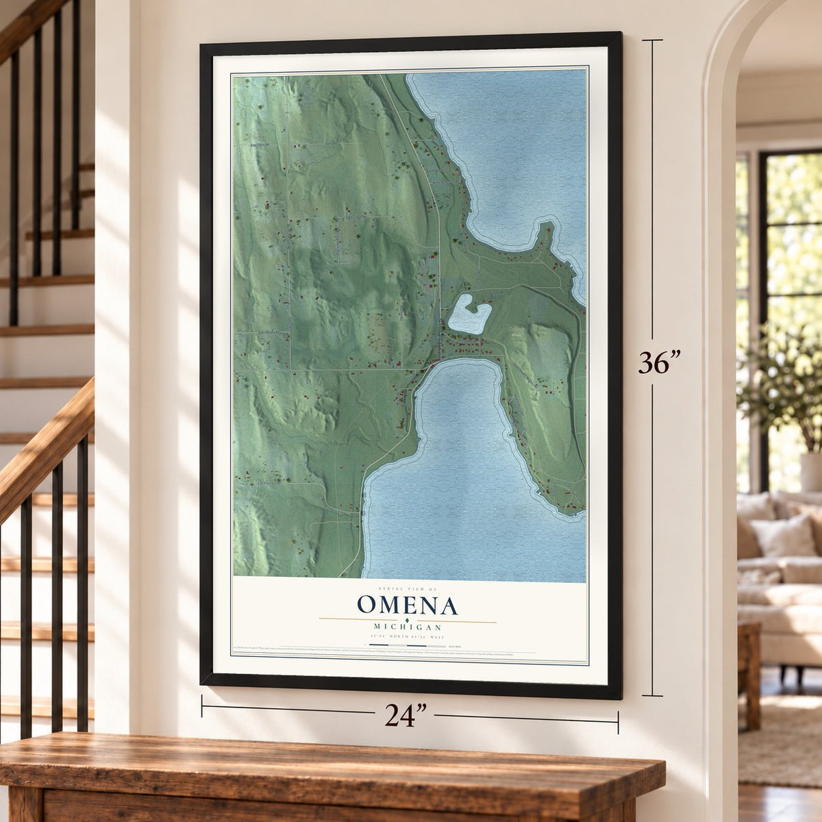 Omena, Michigan map, 24 x 36 inch print in a black frame by a staircase