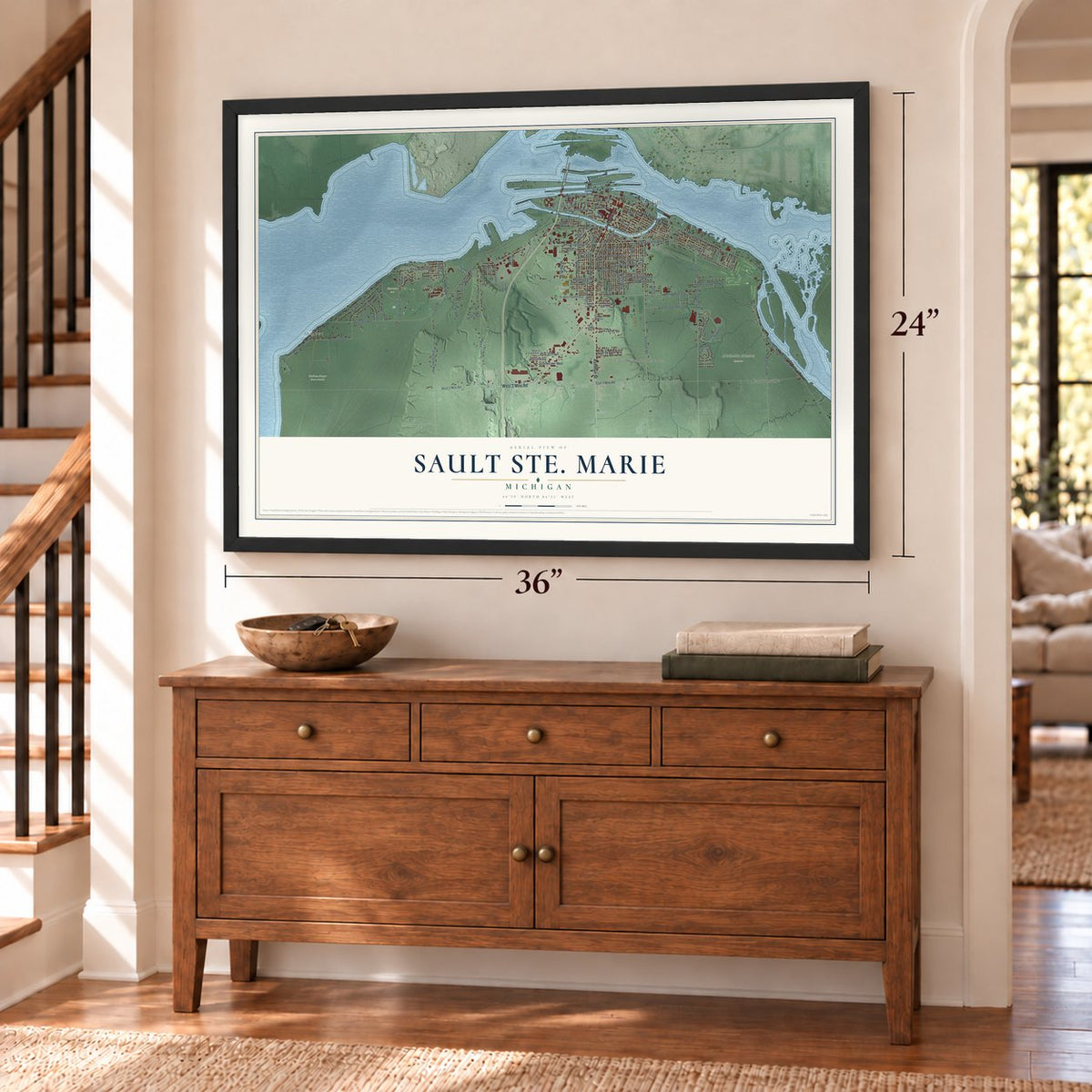 Sault Ste. Marie, Michigan map, 24 x 36 inch print in a black frame above a dresser by a staircase