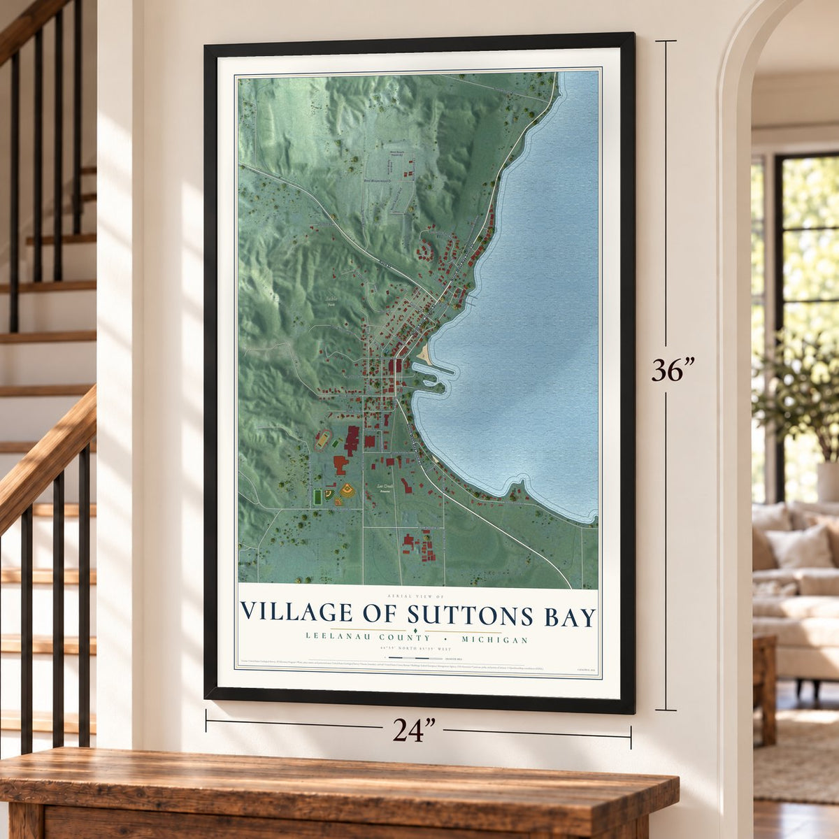 Suttons Bay, Michigan map, 24 x 36 inch print in a black frame by a staircase