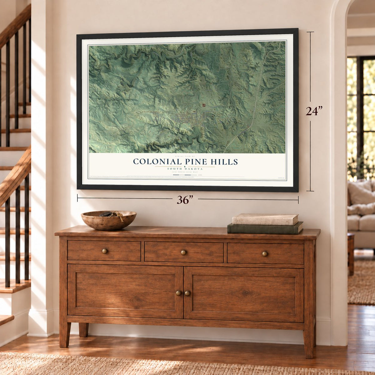 Colonial Pine Hills, South Dakota map, 24 x 36 inch print in a black frame above a dresser by a staircase