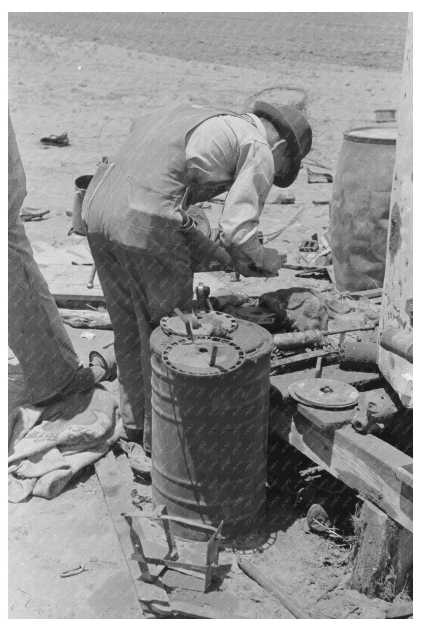 1939 Laborer Adjusting Plow Points on Tractor Planter - Available at KNOWOL