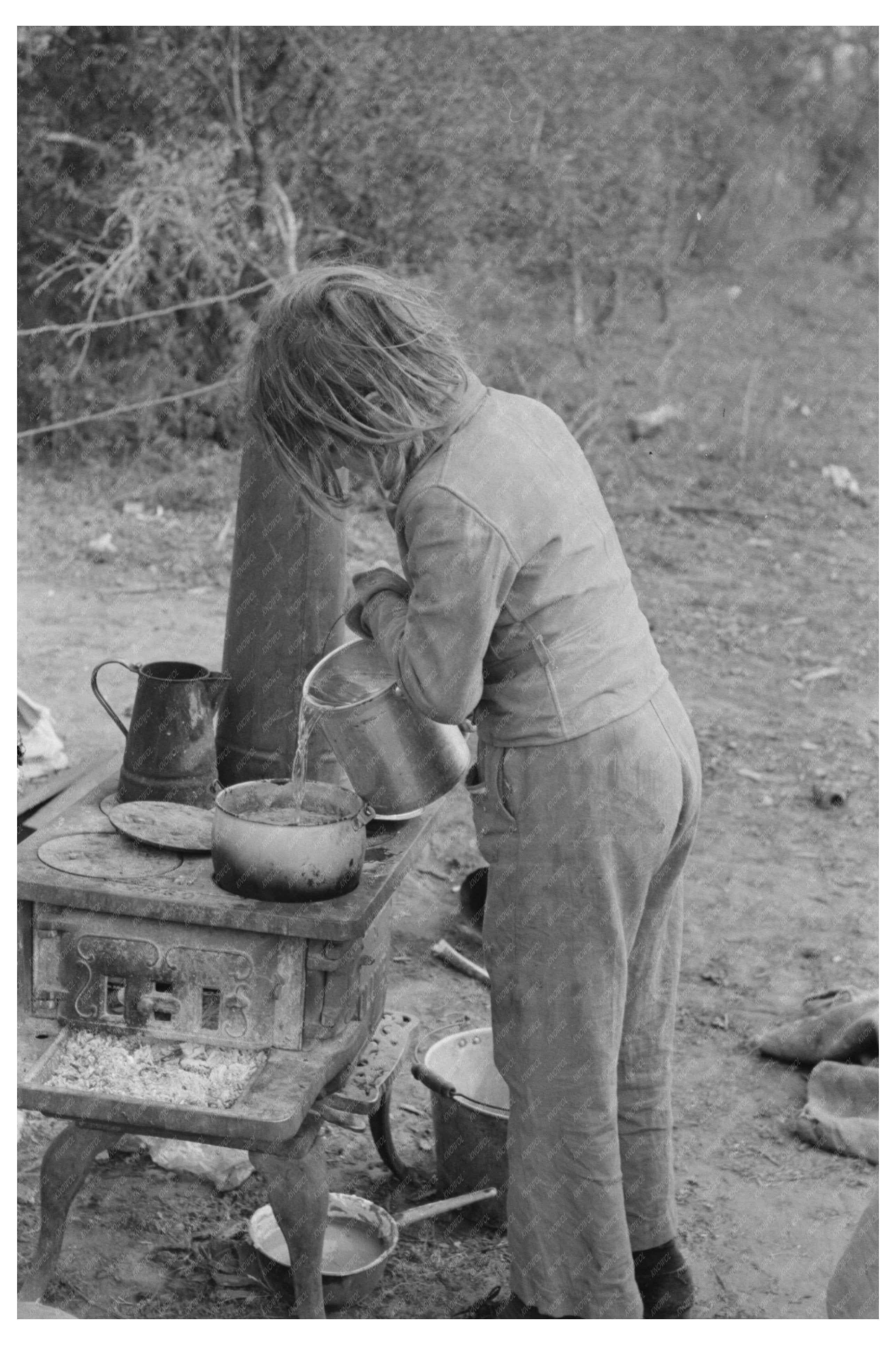 Child Adding Water to Boiling Beans in Texas Camp 1939