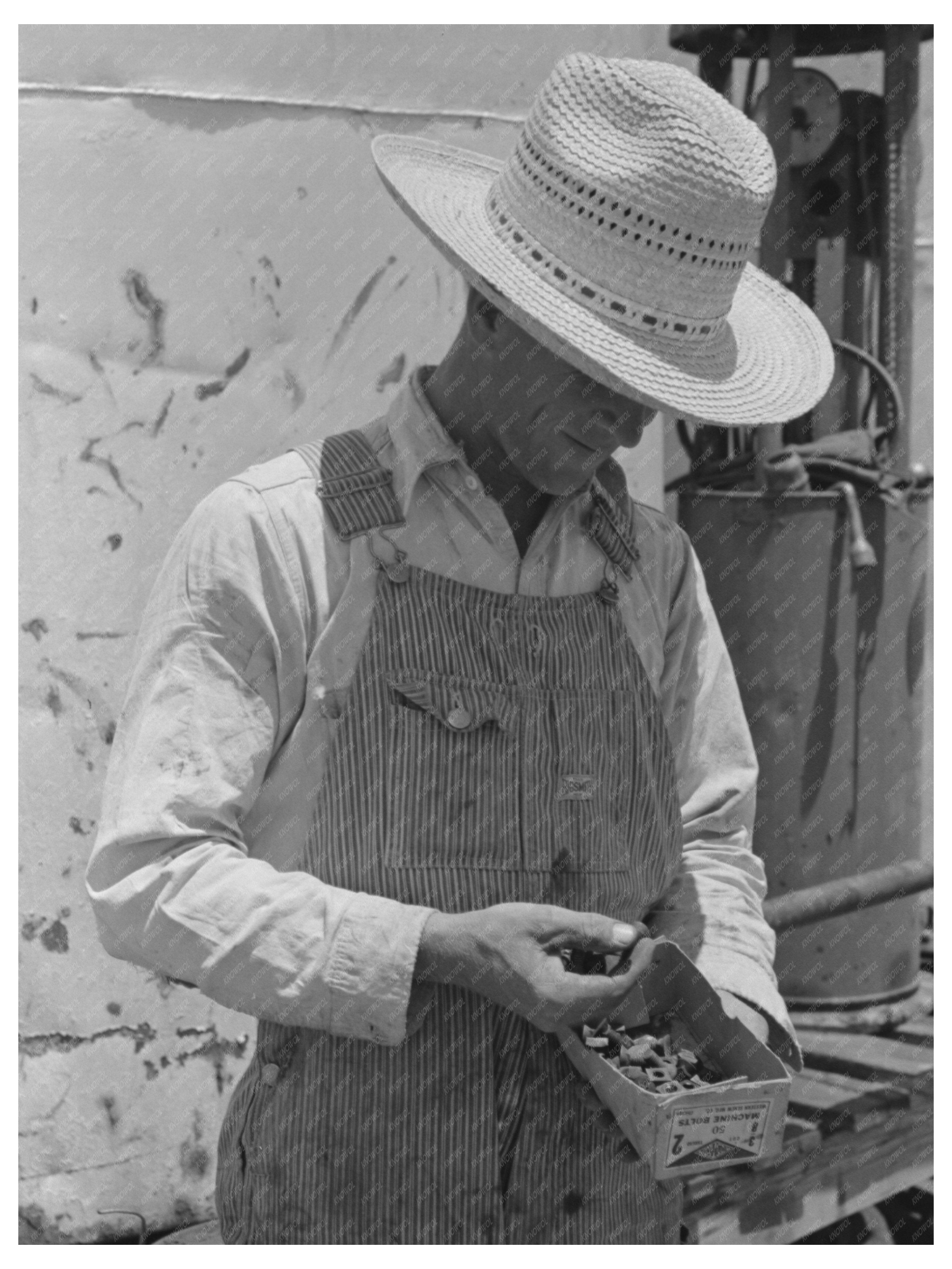 Farm Laborer Examines Nuts and Bolts Ralls Texas 1939