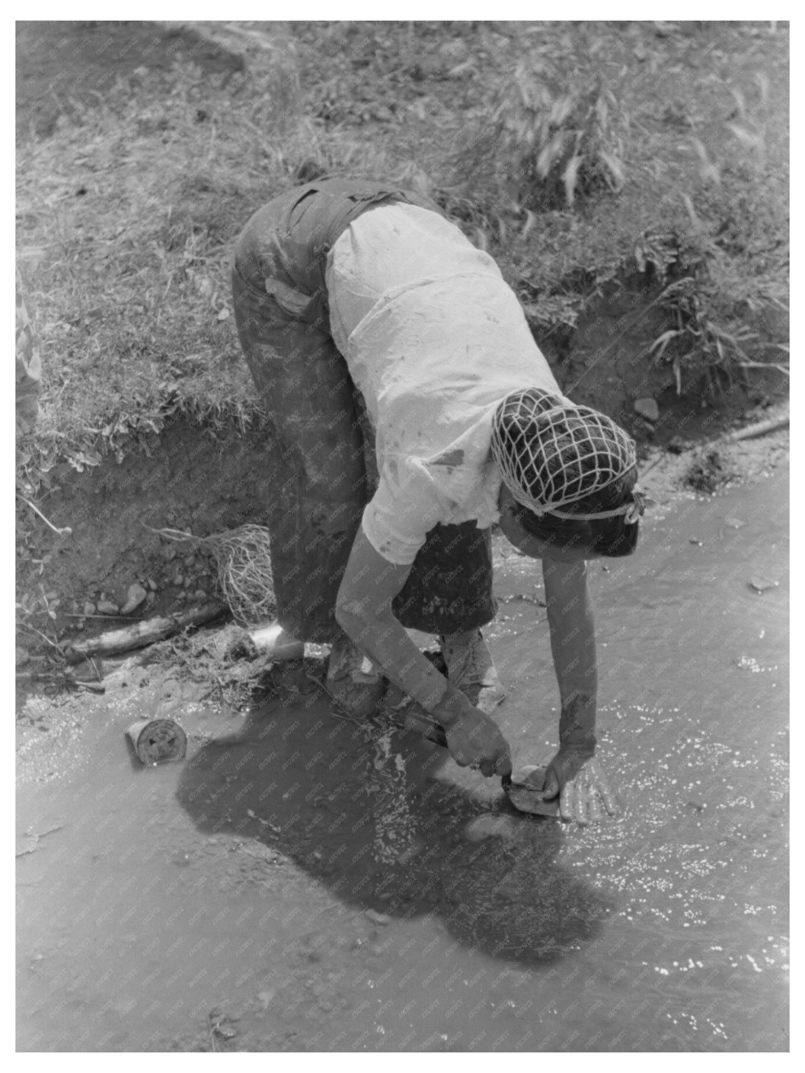 Man Washing Trowel in Chamisal New Mexico July 1940