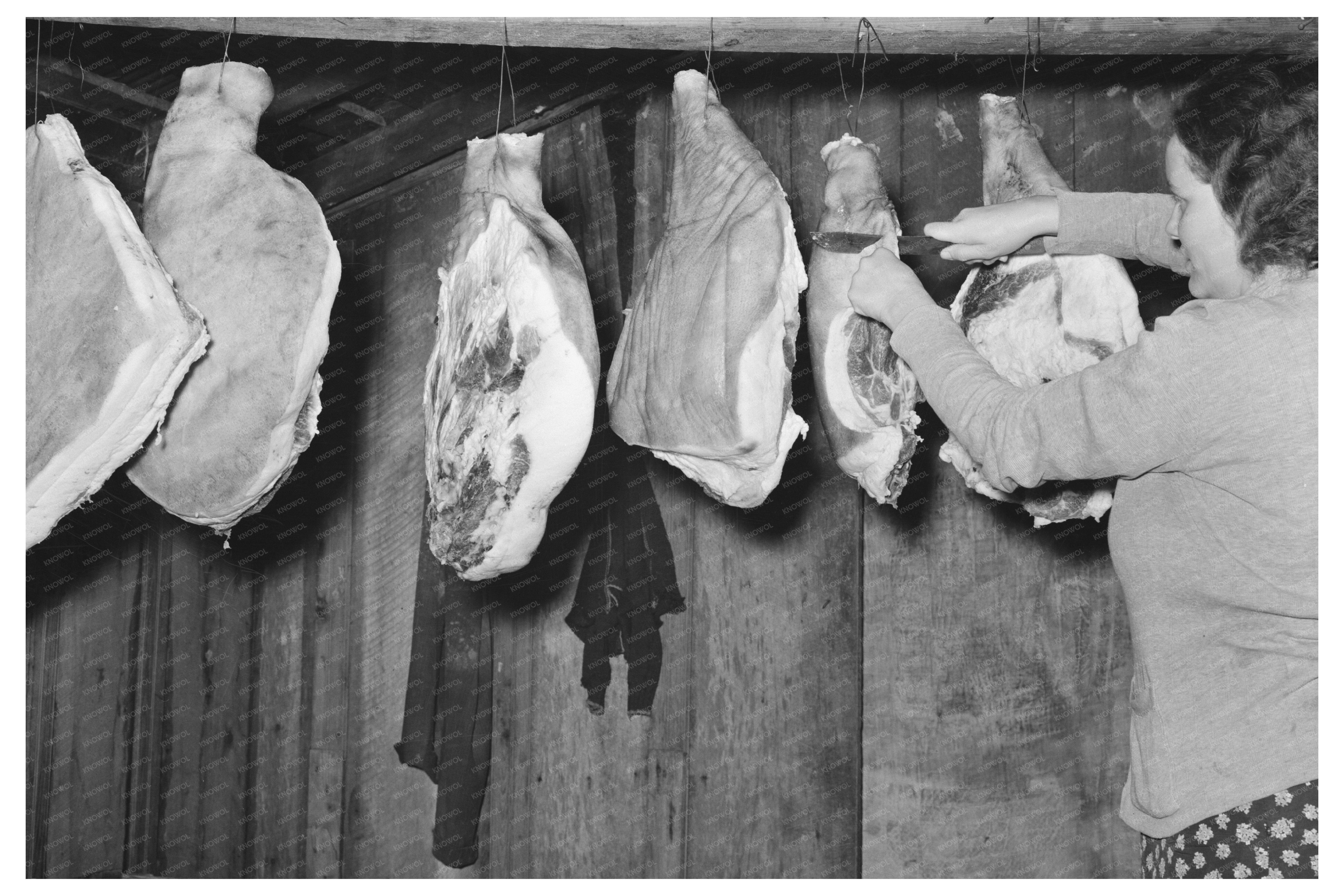 Wife of Tenant Farmer Cutting Ham in Mississippi 1939