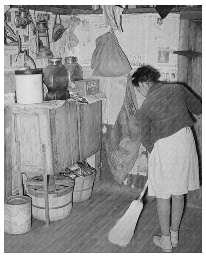 Daughter of Tenant Farmer Sweeping Kitchen February 1944