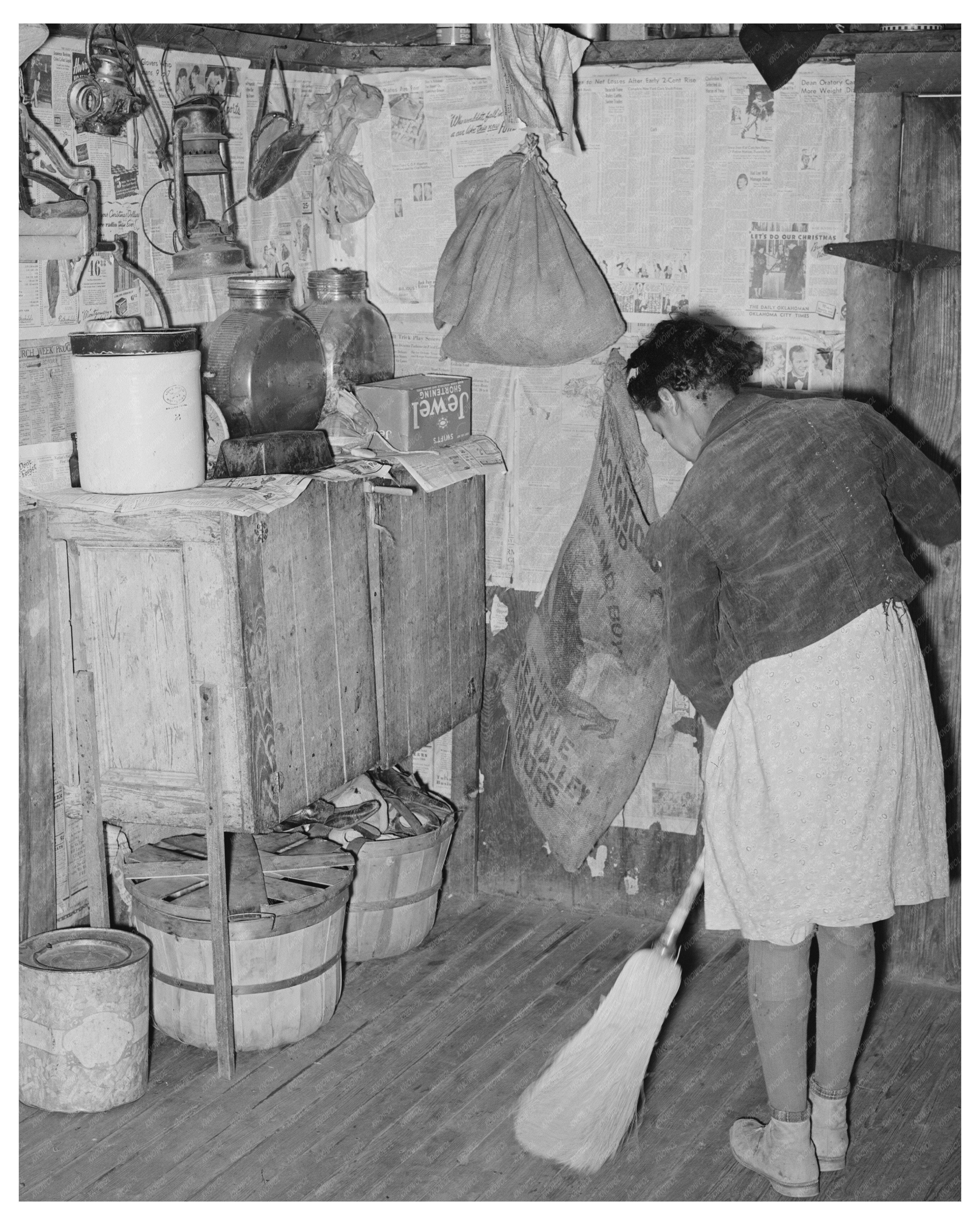 Daughter of Tenant Farmer Sweeping Kitchen February 1944
