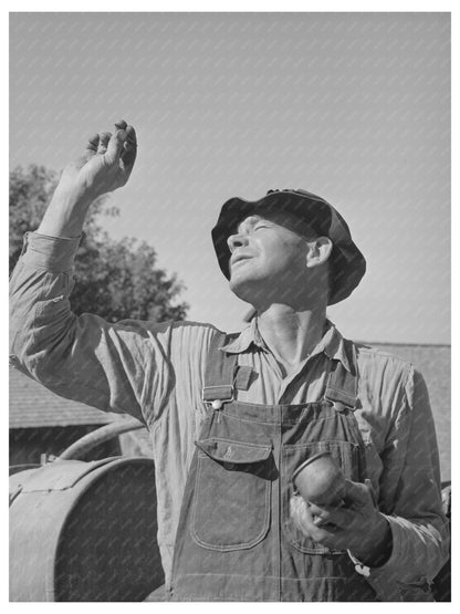 Farmer Inspects Carburetor of Orchard Sprayer August 1940