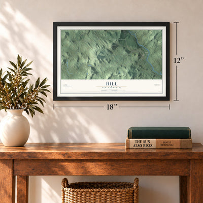 Hill, New Hampshire map, 12 x 18 inch print in a black frame in an entryway
