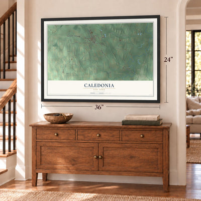 Caledonia, New York map, 24 x 36 inch print in a black frame above a dresser by a staircase