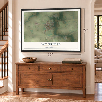 East Bernard, Texas map, 24 x 36 inch print in a black frame above a dresser by a staircase