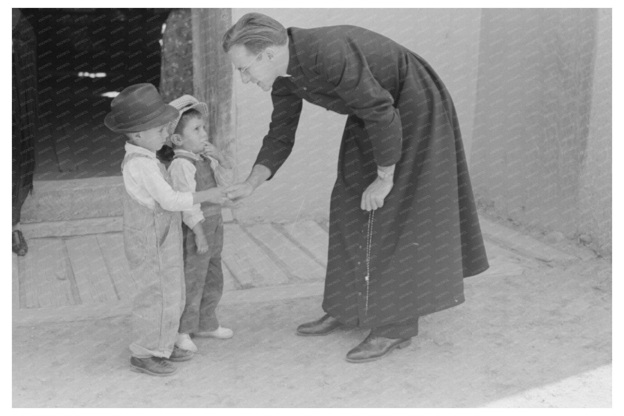 Catholic Priest Greets Boy in Trampas New Mexico 1940 - Available at KNOWOL