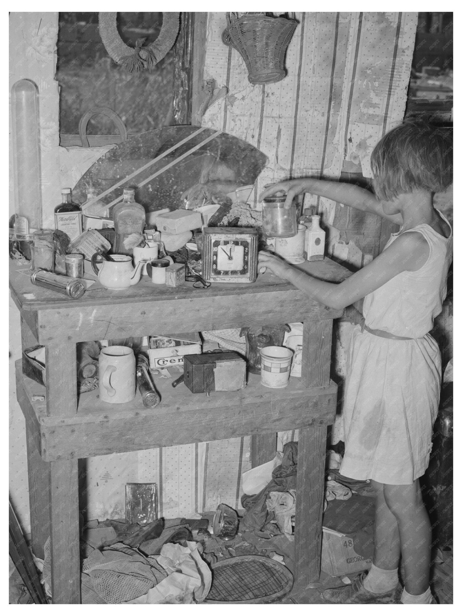 Child at Cluttered Table in Mays Avenue Camp 1939 - Available at KNOWOL