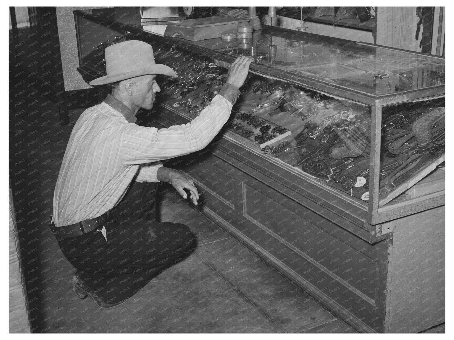 Cowboy Examining Spurs in Alpine Texas 1939 - Available at KNOWOL