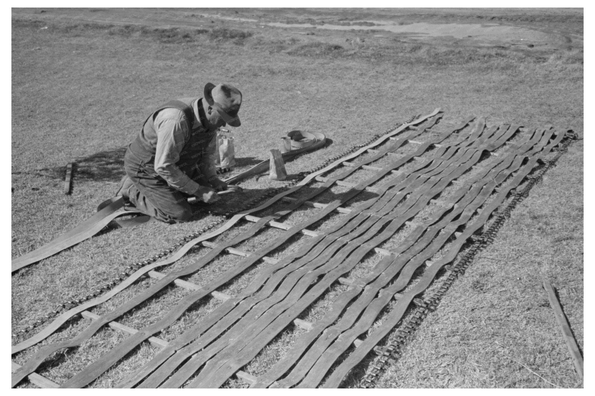 Farmer Repairing Conveyor Belt in Imperial County 1942 - Available at KNOWOL