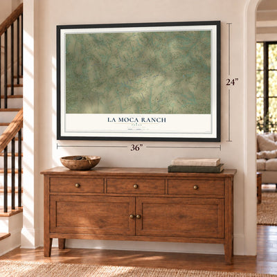 La Moca Ranch, Texas map, 24 x 36 inch print in a black frame above a dresser by a staircase