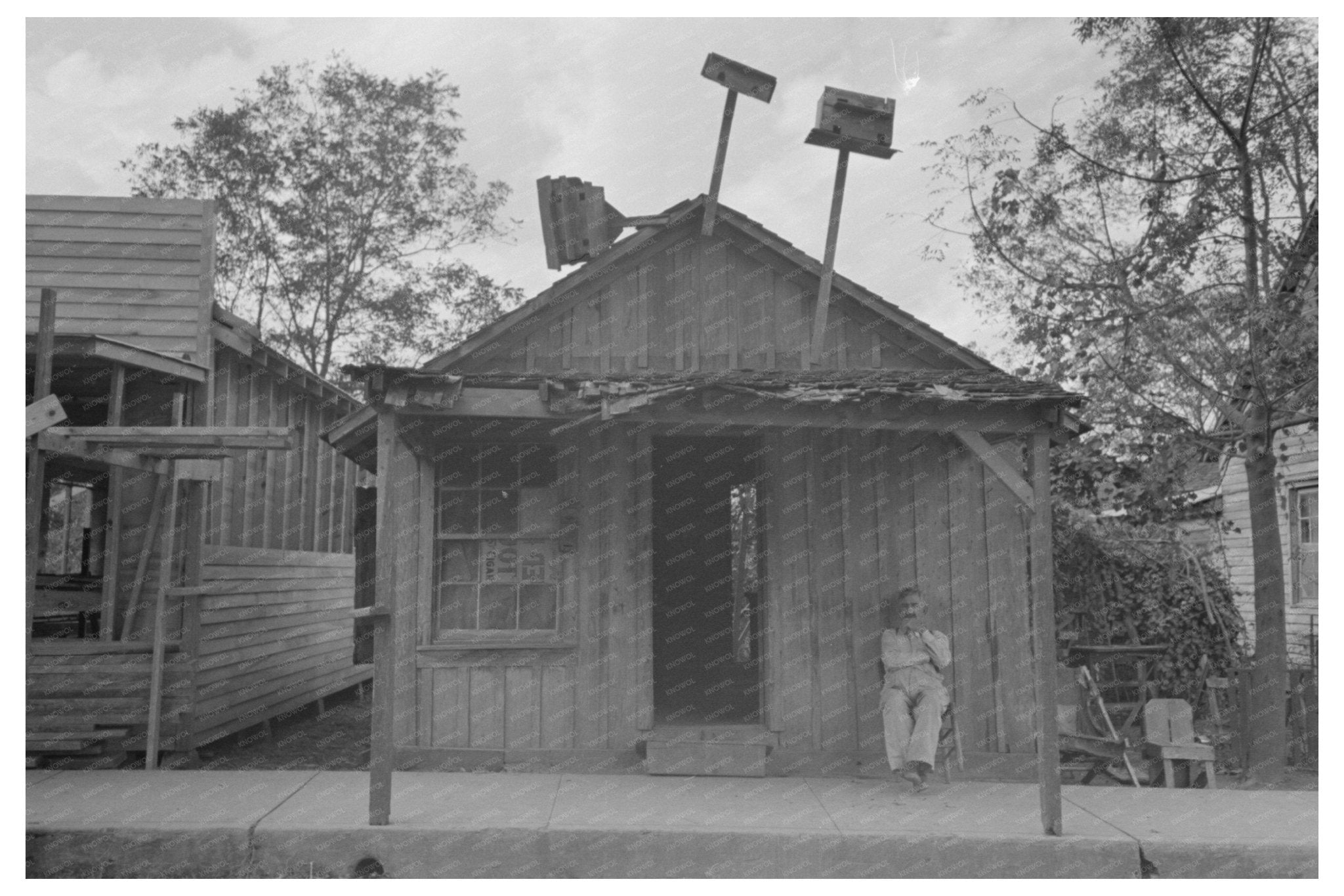 Man Seated Outside Store in Opelousas Louisiana 1938 - Available at KNOWOL