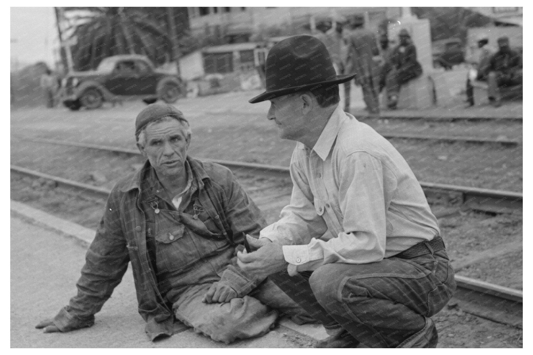 Men Seated on Railroad Platform Raymondville Texas 1939 - Available at KNOWOL