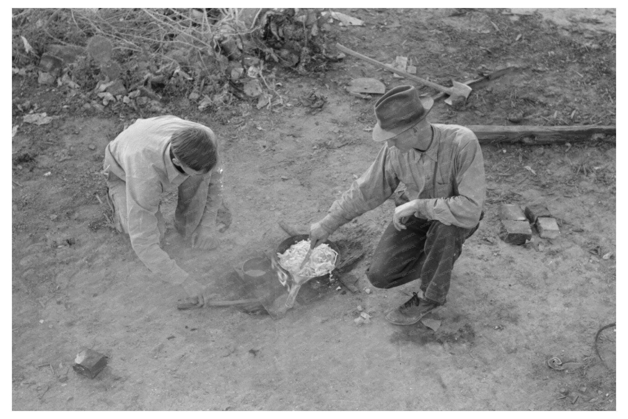 Migrant Father and Son Cooking Over Campfire 1939 - Available at KNOWOL