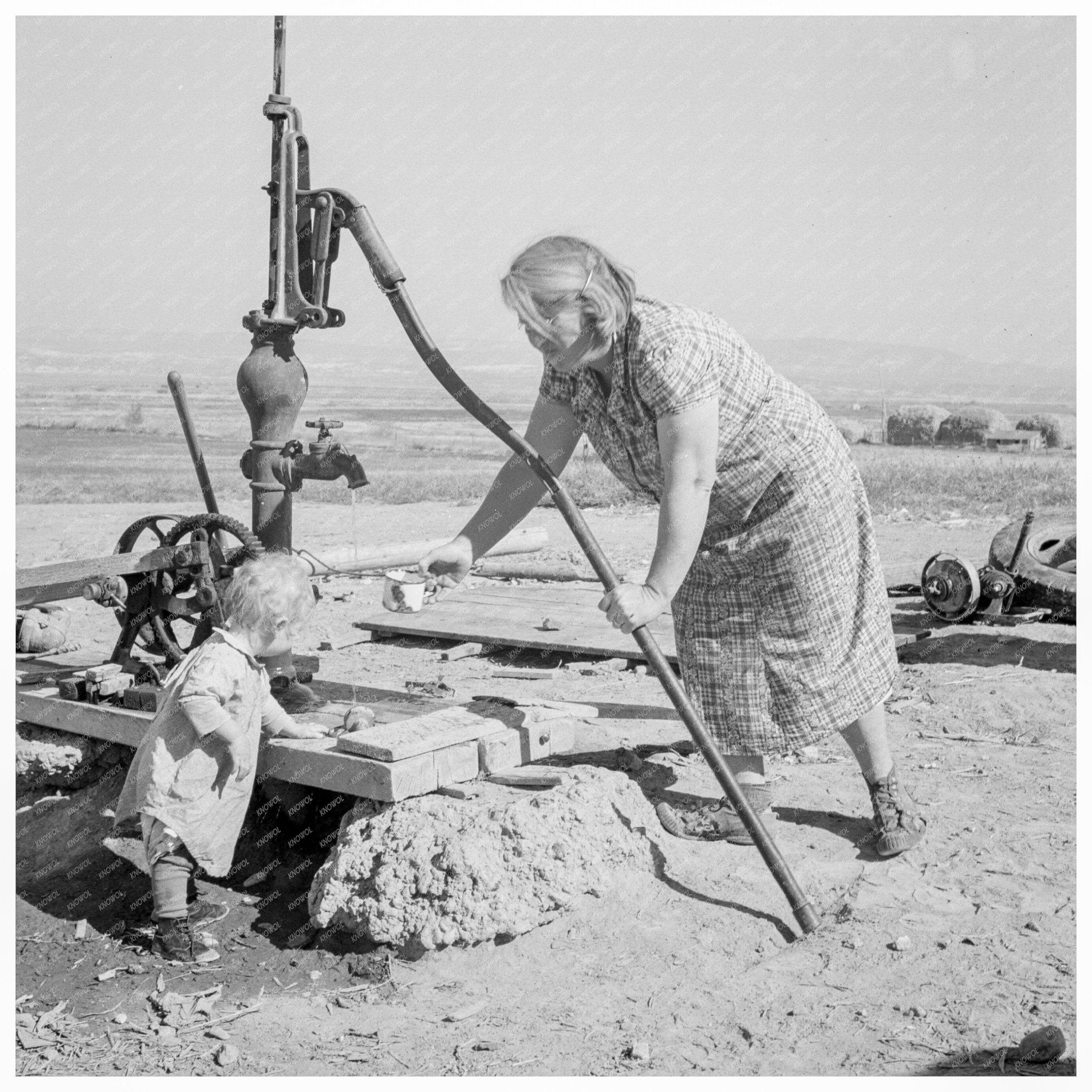 Mrs. Soper at Well with Child Malheur County Oregon 1939 - Available at KNOWOL