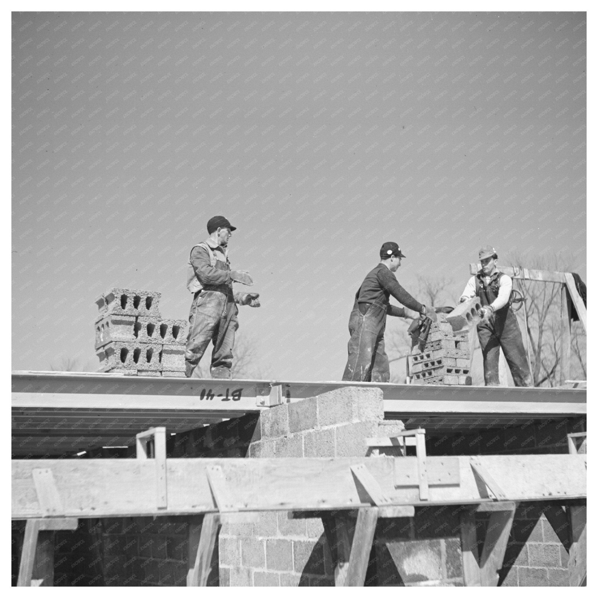 Workers Passing Cinder Blocks on Rooftop Greendale 1937 - Available at KNOWOL